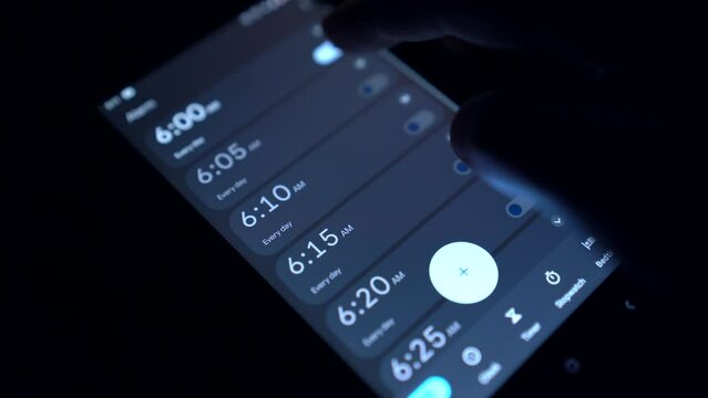 АбстракцияGood morning alarm clock on the phone in the dark room. Set alarm for wake up on cellphone