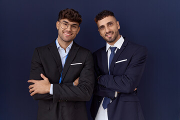 Two hispanic business men wearing business clothes happy face smiling with crossed arms looking at the camera. positive person.