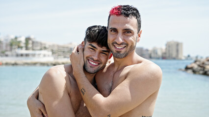 Two men tourist couple smiling confident hugging each other at beach
