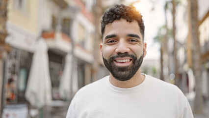 Young hispanic man smiling confident standing at street
