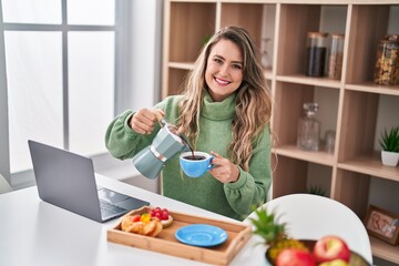 Young woman using smartphone having breakfast at home