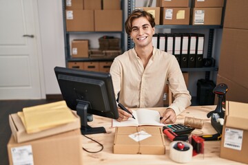 Young caucasian man ecommerce business worker writing on notebook at office