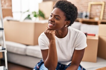 African american woman smiling confident sitting on sofa at new home