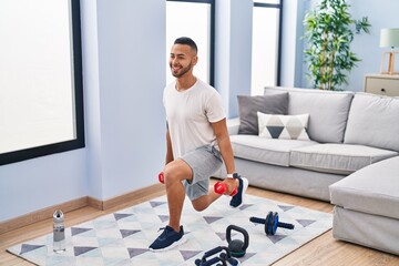 African american man using dumbbells training arms exercise at home