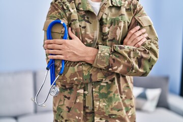 Young hispanic man army soldier doctor holding stethoscope at home