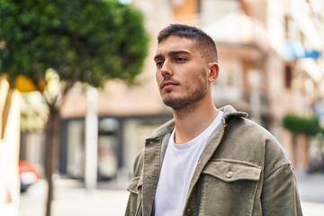 Fototapeta premium Young hispanic man with relaxed expression standing at street