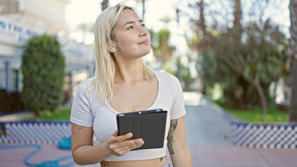 Young beautiful hispanic woman smiling confident using touchpad at park