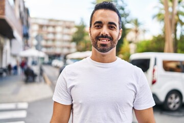 Young hispanic man smiling confident standing at street