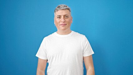 Young caucasian man standing with serious expression over isolated blue background