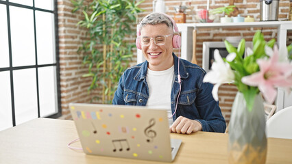 Young caucasian man sitting on table having video call smiling at dinning room