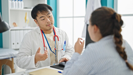 Fototapeta premium Man and woman doctor and patient having medical consultation at clinic