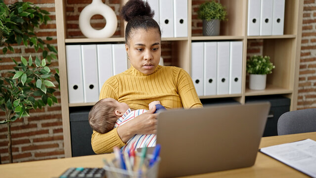 Mother and son business worker working while breastfeeding baby at office