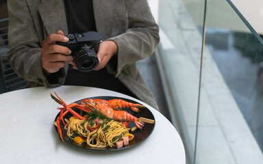 Man taking photo of food at outdoor restaurant