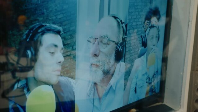 Split screen video on TV of three podcasters in headphones speaking in microphones in a recording studio during live stream. Close-up view of TV display or computer monitor