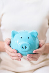 Fototapeta na wymiar Money Saving for Future Plan, Retirement fund, Pension, Investment, Wealth Business and Financial concepts. hand holding and putting into piggy bank, Money Counting for World Savings day and Donate