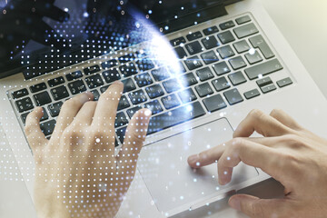 Double exposure of abstract digital world map and hand typing on laptop on background, big data and blockchain concept