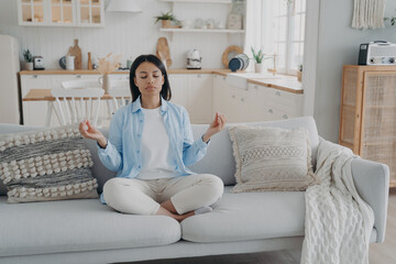 Zen, tranquility and breath control. Spanish woman is practicing yoga gymnastics in living room.
