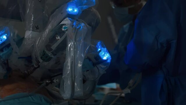 Moving robotic arms of minimally invasive da vinci medical surgical system. Sterile operating room of modern technological clinic