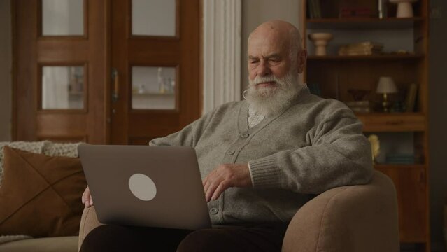 Senior Man Using Laptop in Armchair