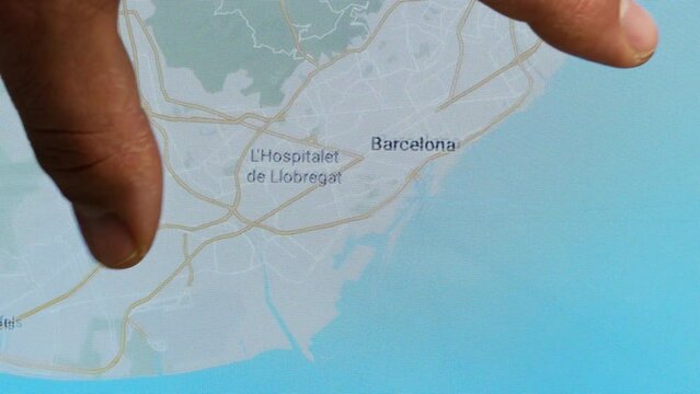 Close up hand gesture on touch screen zoom in barcelona city Spain