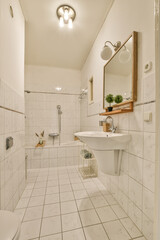 a bathroom with white tile and wood trim around the tub, toilet, sink, and mirror on the wall