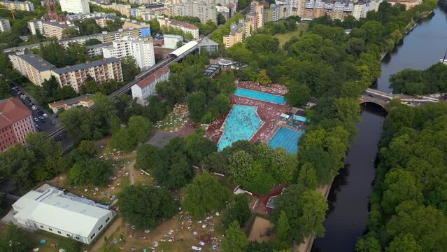 crowded public swimming pool, city Berlin. Dramatic aerial top view flight drone