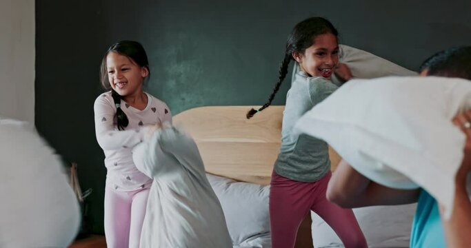 Happy, bedroom and children in a pillow fight with their parents for fun, playful or bonding together. Happiness, smile and girl kids playing with their mother and father on bed in their family home.