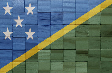 colorful painted big national flag of Solomon Islands on a wooden cubes texture.