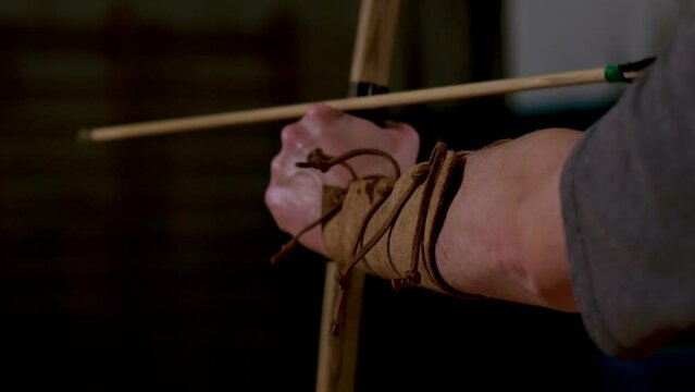 archer tends yew wood bow to shoot an arrow