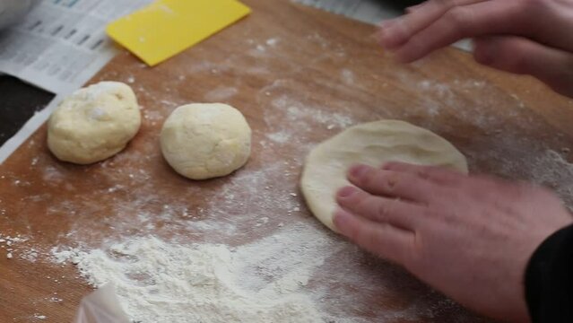person kneading dough on the table
