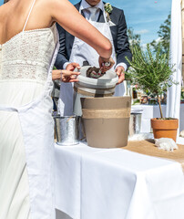 Wedding ceremony couple bride and groom planting a pot with rosemary tradition - 624765751