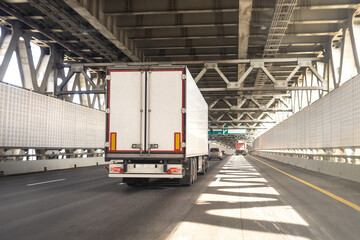 Truck is driving down road. Automobile cargo transportation. Truck with white body back view. Lorry...