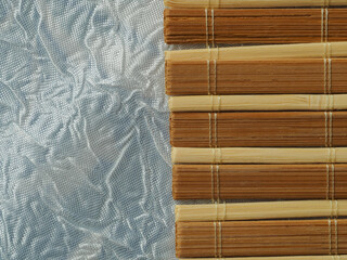 bamboo texture, material with a visible pattern, dark yellow and light planks tied with a string, bamboo mat, in the light and shadow. background, wallpaper for various graphics