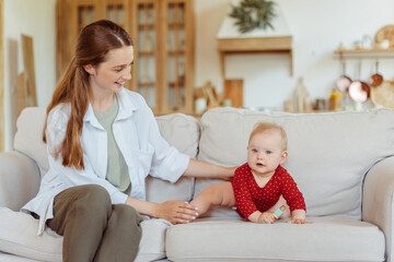 Obraz premium Young smiling babysitter spending time with cute little baby