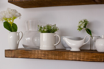 Wooden kitchen with floral decor. Cozy home decor. Kitchen utensils, dishes and a plate on the table. kitchen table in the dining room. Stylish kitchen with flowers in a vase. Comfort in home