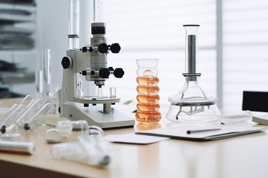 Microscope and test tubes on the table in a modern laboratory. AI generated