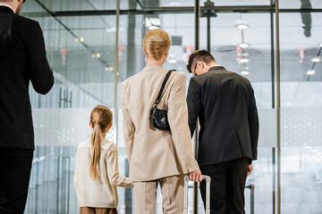 security service, personal protection, back view of blonde woman and her daughter leaving hotel...