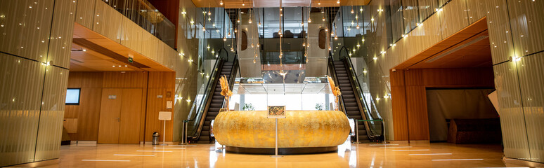 modern hotel interior with round reception desk and sophisticated lobby design, escalators, moving...