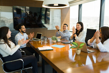 Group of businesspeople clapping hands after successful meeting