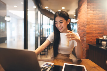 Happy business freelance asian woman holding coffee cup at cafe urban lifestyle