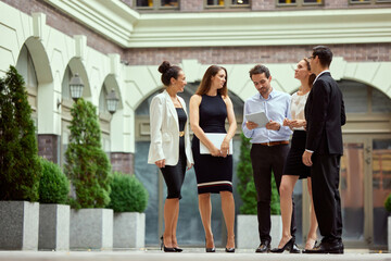 Fototapeta premium Group of people, colleagues, employees standing outside the office, walking, talking. Friendly team and managers. Concept of business, career development, ambitions, success, office lifestyle