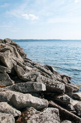Turgoyak lake in summer with boulders on its coast in the foreground, South Ural, Russia