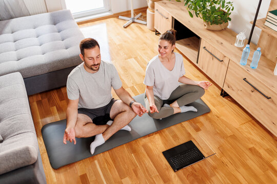 Couple exercising yoga at home