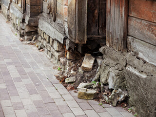 Old wooden building with falling apart brick and concrete basement. Poor area of town. Poverty...
