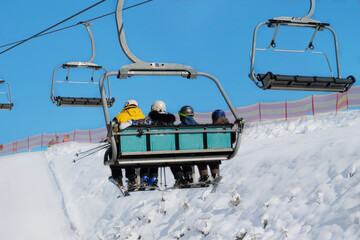 Skiers go up the mountain on the lift in ski resort. Skiing in winter. Vacation in mountains in ski resort.