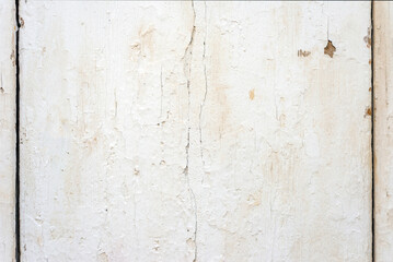 Close up photo of a wooden plank covered with white old cracked paint. Abstract background