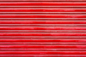 Textured background of red wooden roller shutter door close up