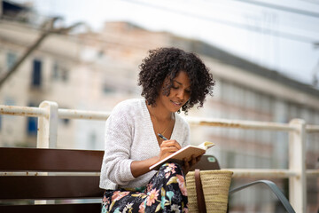 young african american woman writing in book