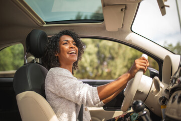 smiling young african american woman driving car - 624781537