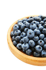 Fresh blueberry in wooden bowl isolated on background. Top view. Concept of healthy and dieting eating. Vertical photo